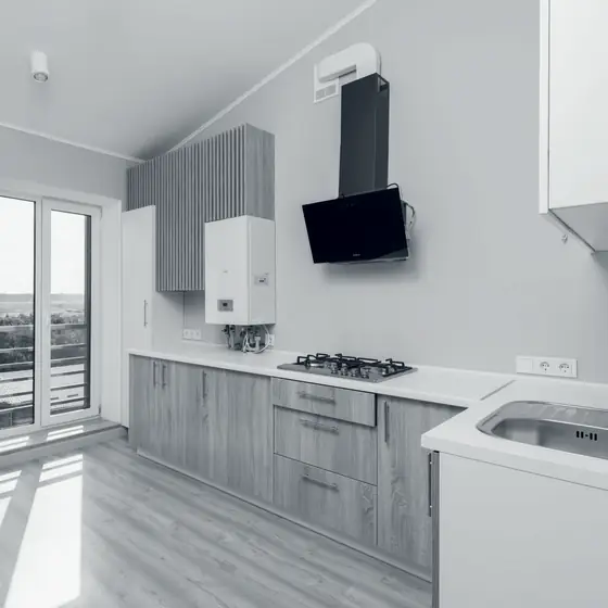 Bucătărie de apartament cu centrală termică și hotă pe perete