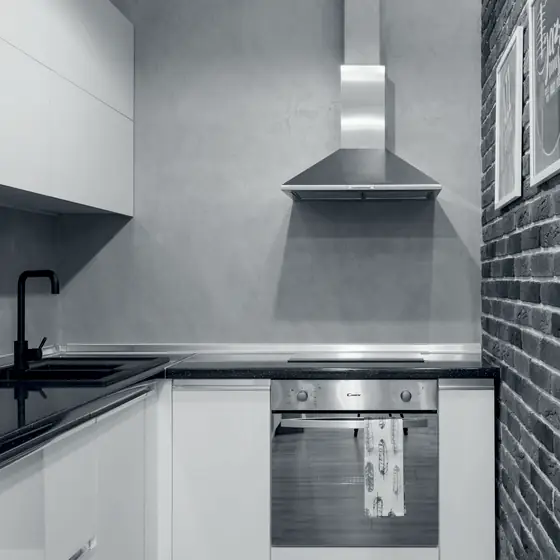 Bucătărie de apartament cu hotă din inox montată pe perete